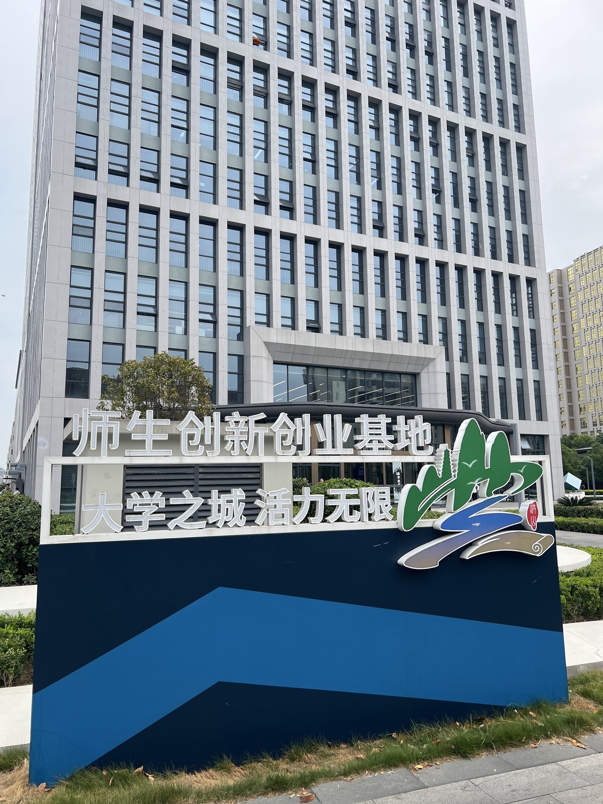 现场拍摄的师生创新创业基地标识，写有大学之城活力无限